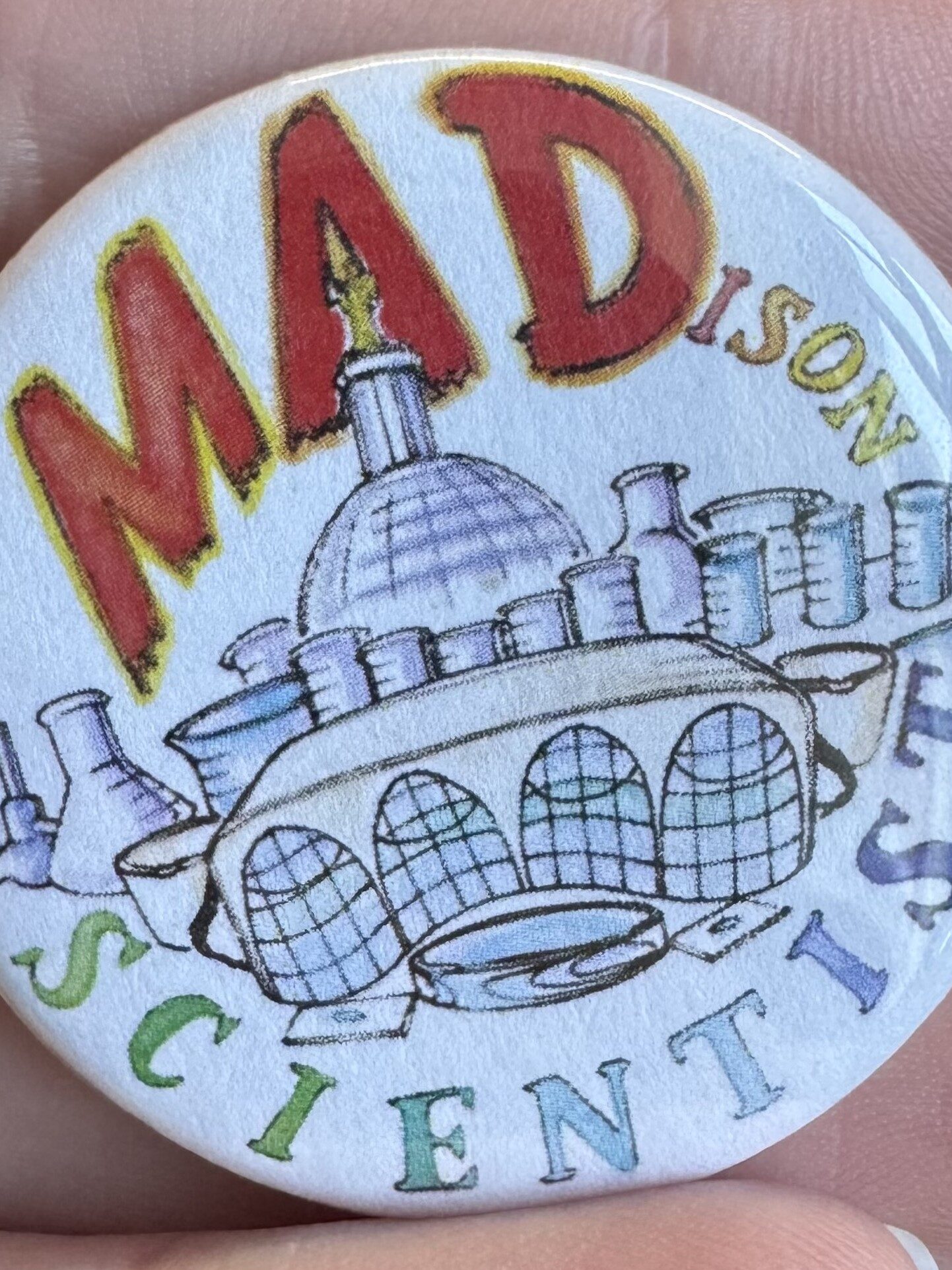 Photo of a button with the inscription "Mad" ison Scientist